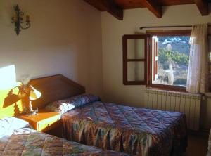 VilallerにあるCasa Enriu-Alojamiento y desayunoのベッド2台と窓が備わるホテルルームです。