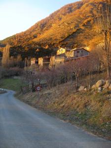 a road with a house on the side of a hill at Casa Enriu-Alojamiento y desayuno in Vilaller