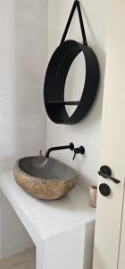 een badkamer met een stenen wastafel en een spiegel bij Almyriki in Mylopotas