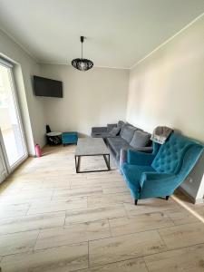 - un salon avec un canapé bleu et une table dans l'établissement Apartamenty 53, à Wielen Zaobrzanski