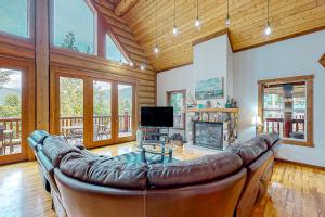 a large leather couch in a living room with a fireplace at Lakeview Chalet in Christina