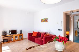 a living room with a red couch and a table at Il Giardino di Laura in Costa Volpino