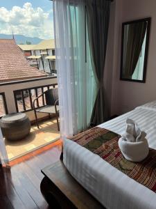 a bedroom with a bed with a view of a balcony at Pha Thai House in Chiang Mai
