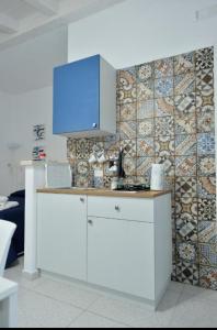 a kitchen with a counter with a tv on a wall at Scala dei Turchi Luxury Home in Realmonte