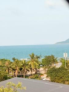 Blick auf einen Strand mit Palmen und das Meer in der Unterkunft Hùng Đức Hotel Cửa Lò in Cửa Lô