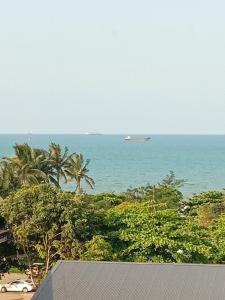 a boat in the ocean with palm trees and the beach at Hùng Đức Hotel Cửa Lò in Cửa Lò