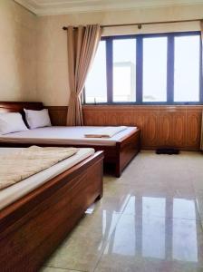 1 dormitorio con 2 camas y ventana grande en Hùng Đức Hotel Cửa Lò, en Cửa Lô