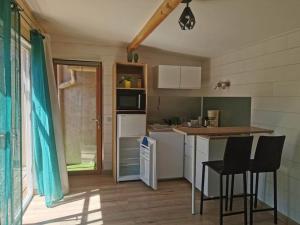 a kitchen with a counter and chairs in a room at chalet proche de la mer in La Crau