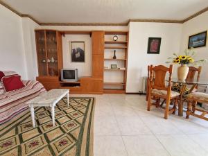 ein Wohnzimmer mit einem Sofa und einem Tisch in der Unterkunft Precioso apartamento con piscina - Covelo in Pontevedra