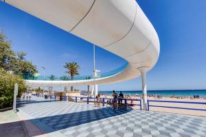 a white canopy over a beach with people on it at HB Apartments - Luceros Luxury Loft in Alicante