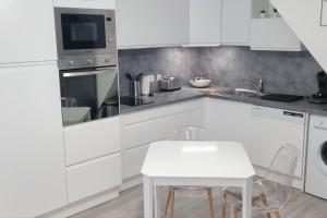 a kitchen with white cabinets and a white table at Apollinaire - Très jolie maison - Jardin - 3pers in Lille +5 photos