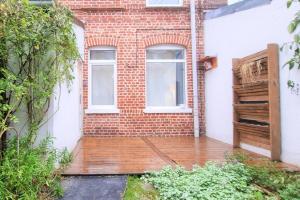 a porch of a brick house with a wooden deck at Apollinaire - Très jolie maison - Jardin - 3pers in Lille