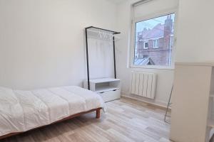 a white bedroom with a bed and a window at Apollinaire - Très jolie maison - Jardin - 3pers in Lille