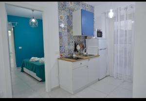 uma cozinha com armários brancos e uma parede azul em Scala dei Turchi Luxury Home em Realmonte