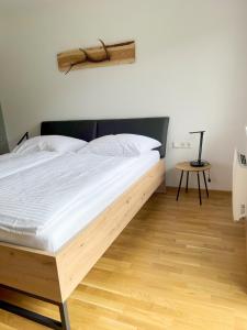 duże łóżko w pokoju z drewnianą podłogą w obiekcie Eden 44 - Top 5 w mieście Tamsweg