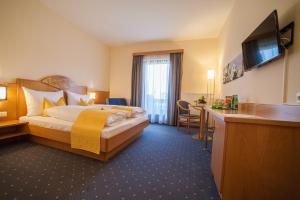 pokój hotelowy z łóżkiem i biurkiem w obiekcie Gasthof Mauthner Zum Kirchenwirt w mieście Wies