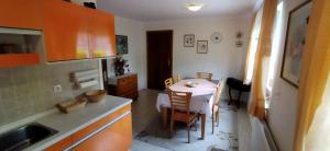 una cucina con un tavolino e una cucina con armadietti arancioni di Apartmani Horvat - Varaždinske Toplice a Varaždinske Toplice