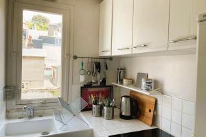 une cuisine avec un évier et une fenêtre dans l'établissement luminous apartment in the heart of trouville, à Trouville-sur-Mer