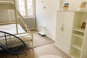 a bedroom with a bunk bed and a chair at luminous apartment in the heart of trouville in Trouville-sur-Mer