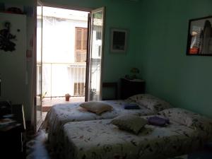 ein Schlafzimmer mit einem Bett in einem Zimmer mit einem Fenster in der Unterkunft Mare e Monti in Giardini-Naxos