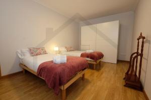 2 camas en una habitación con suelo de madera en Cabrales - Parking Gratis - WiFi - A un paso del centro, en Gijón