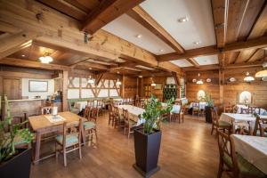 restauracja z drewnianymi sufitami, stołami i krzesłami w obiekcie Gasthof Mauthner Zum Kirchenwirt w mieście Wies