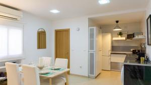 kuchnia i jadalnia ze stołem i krzesłami w obiekcie Apartment Caleta Beach Málaga w Maladze
