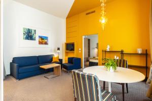 a living room with a blue couch and a table at HiLight Suites Hotel in Vienna