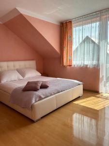 - un grand lit dans une chambre avec une grande fenêtre dans l'établissement Pensjonat Wiktoria, à Międzywodzie