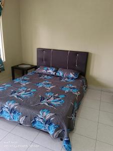 a bedroom with a bed with a brown bedspread with a dragon pattern at ALZA BUDGET ROOMStay in Pantai Cenang