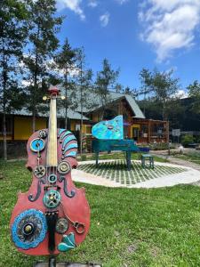 a guitar statue sitting in the grass in a park at 方圓行止 Funyuan Village in Puli