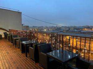 einen Balkon mit Tischen und Stühlen auf einem Gebäude in der Unterkunft Hotel Andy in Bukarest