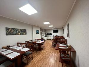 Hotel Andy في بوخارست: غرفة طعام مع طاولات وكراسي خشبية