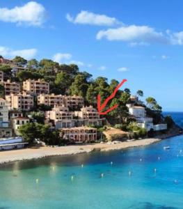 a red kite is flying over a beach at Beach Apartment Montemar No.1 - perfect ocean view in Sóller