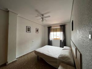 - une chambre avec un lit et un ventilateur de plafond dans l'établissement Amplio y luminoso apartamento, à Sagonte
