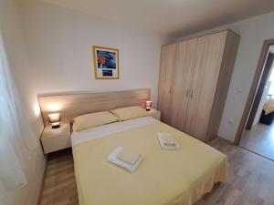 a bedroom with a bed with two towels on it at Apartments Fran I in Baška