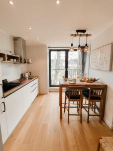 a kitchen with a wooden table and a dining room at Beautiful Seaside apartement Albatross 23 in Ķesterciems