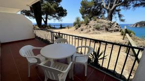 a table and chairs on a balcony with a view of the ocean at Appartements sol y mar cala llevado in Tossa de Mar
