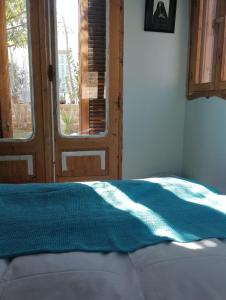 1 cama con manta azul en una habitación con ventana en Barefoot by Barefoot in Tunis, en ‘Izbat an Nāmūs