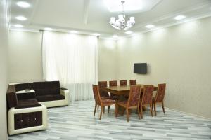 a dining room with a table and chairs and a couch at Foothills Villa in Gabala