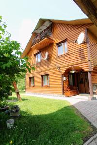 a large wooden house with a green yard at Cottage "Kliverent" in Yaremche