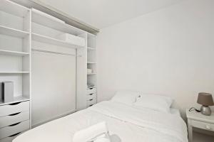 ein weißes Schlafzimmer mit einem Bett und einem Schreibtisch in der Unterkunft Le Glatigny- Chesnay in Le Chesnay