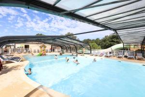 um grupo de pessoas a nadar numa piscina em Camping Le Petit Rocher em Longeville-sur-Mer