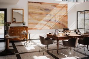 a dining room with tables and a large painting on the wall at maison 41 in Bad Gleichenberg