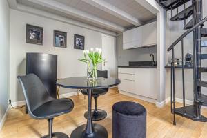 Casa Dafne in Canton de Fiori في بولونيا: مطبخ وغرفة طعام مع طاولة وكراسي