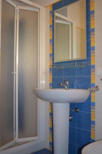 ein Bad mit einem Waschbecken und einer Dusche mit einem Spiegel in der Unterkunft Vacanze Morfino in Castelluzzo