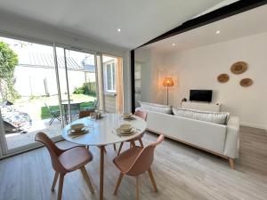 uma sala de estar com um sofá, uma mesa e cadeiras em Jaurès 1 -T2- 4p - Tramway - Gare - Centre ville em Le Mans