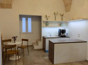 a kitchen with a counter and a table and chairs at CASATA in Copertino