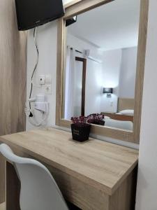 a bathroom with a vanity with a mirror and a chair at Stavroula's House in Skiathos