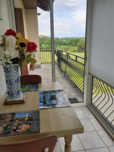 stół z wazą kwiatów na balkonie w obiekcie Maison de la Devèze w mieście Mourjou